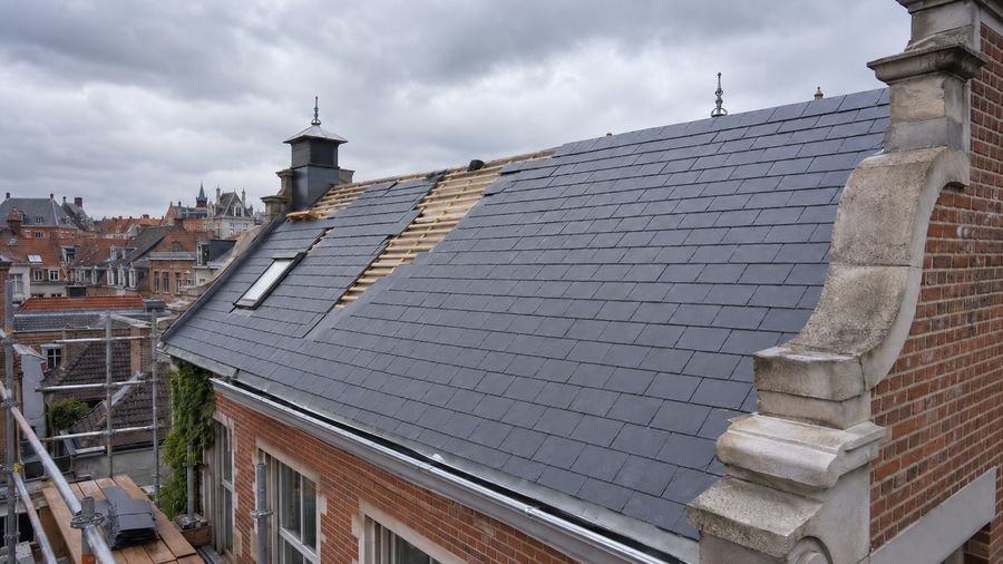 Couverture en ardoise avec voliges apparentes en cours de pose à Roujan